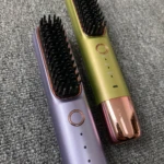 Cepillo alisador de cabello inalámbrico morado y verde con configuración de temperatura.