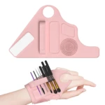 Pulsera de silicona rosa para organizar brochas de maquillaje en la mano.