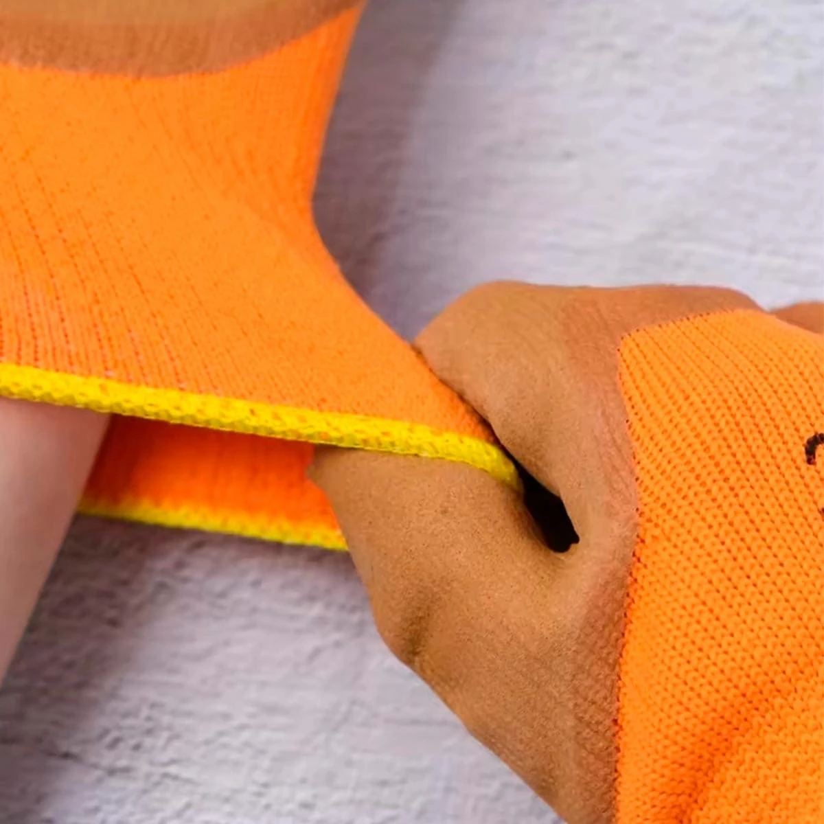 Manos enguantadas de trabajo GP-300 con ajuste de cuerda en primer plano.