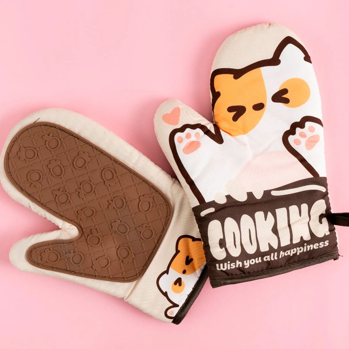 Guantes para hornear con diseño de gato y texto "COOKING" en fondo rosa.