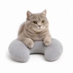 Gato gris tierno en almohada de viaje para mascotas, diseño ergonómico para confort.