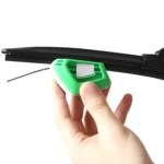 Afilador de plumillas para limpiaparabrisas automotriz en mano, color verde y blanco.