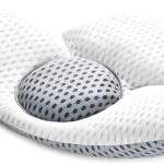 Almohada lumbar ergonómica con centro de malla transpirable y diseño contorneado para soporte.