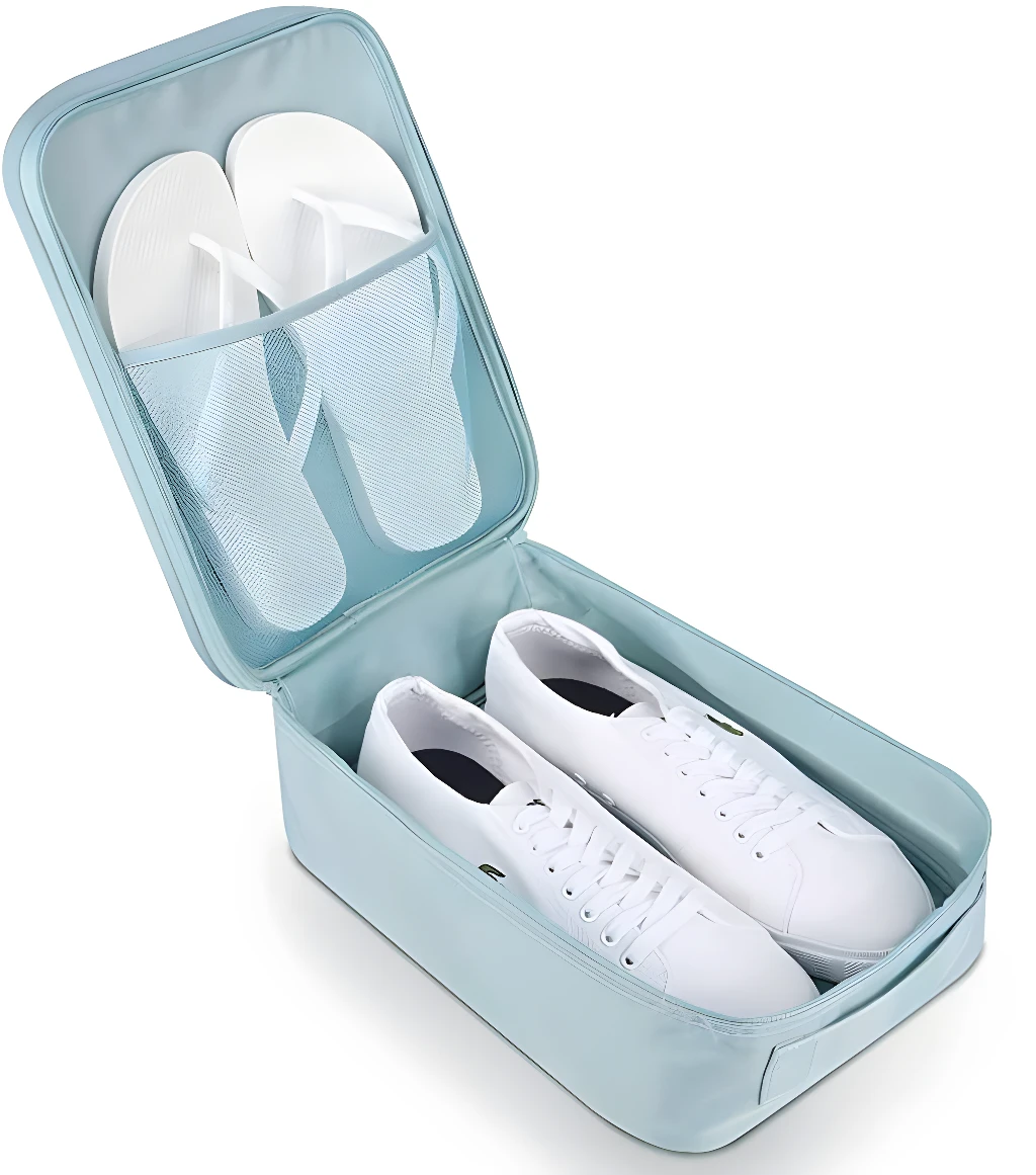 Bolso de viaje azul con zapatillas blancas y chanclas en compartimentos de malla.