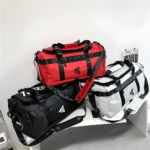 Bolso viajero multiuso rojo, negro y gris, ideal para deportistas y viajes cortos.