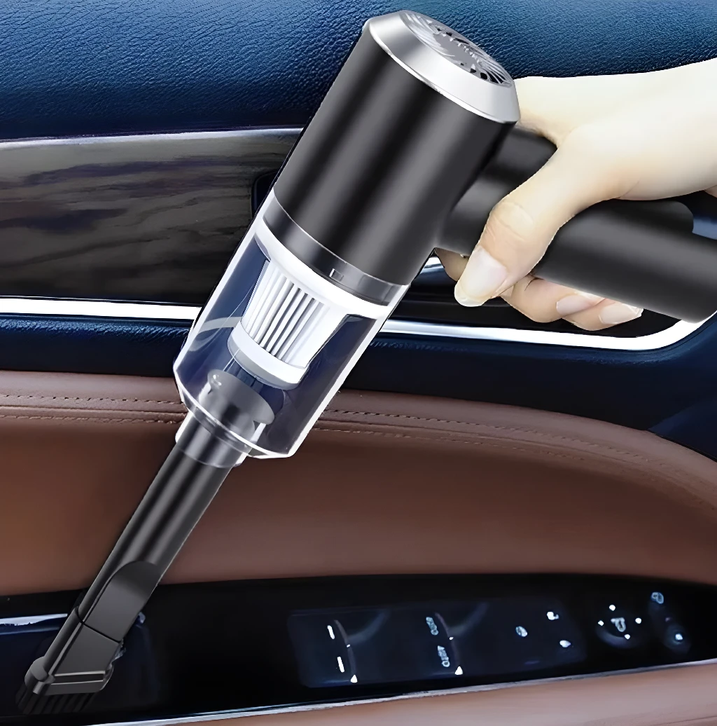 Aspiradora portátil negra de mano limpiando panel de puerta de automóvil con accesorios.