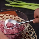 Cuchara para albóndigas forma bolas perfectas de carne molida en un bol.