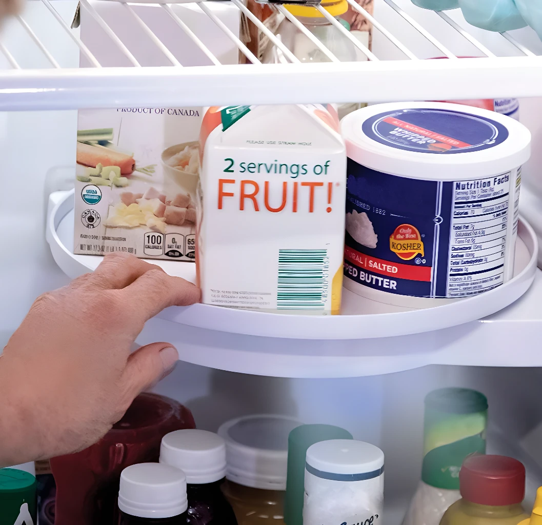 Estante giratorio para organizar la nevera con envase de "2 servings of FRUIT!" y mantequilla.