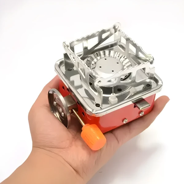 Estufa a gas butano portátil compacta en mano, ideal para camping y exteriores.
