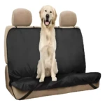 Perro golden retriever sentado en forro protector negro para silla de carro.