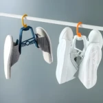 Gancho secador para colgar chanclas y zapatillas blancas, ideal para secado al aire.
