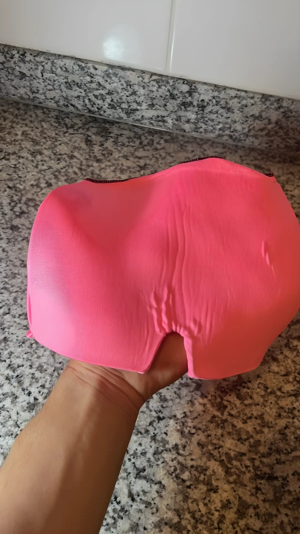 Gorro para migraña relajante rosa brillante en mano, ideal para alivio del dolor.