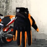 Guantes de moto impermeables SU09 negros y naranjas con protección de impacto y diseño deportivo.