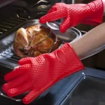 Guantes Hot rojos de silicona para horno con pollo asado y utensilios de cocina.