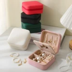 Joyero organizador bolso viajero rosa abierto con collares, aretes y perlas.