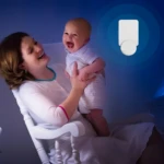 Lámpara mata mosquitos junto a madre e hijo riendo en silla mecedora