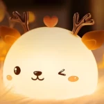 Lámpara de silicona de reno kawaii con cuernos dorados y corazón, luz tenue.
