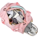 Maleta impermeable de gimnasio color rosa con tenis de cuadros, laptop y accesorios.