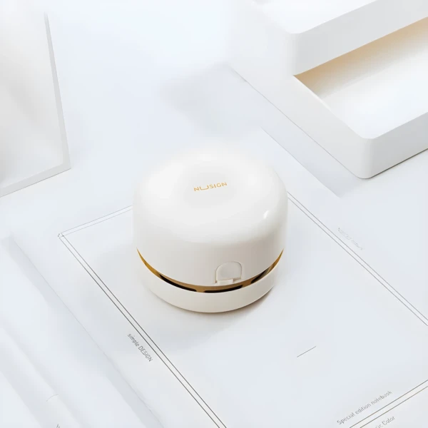 Mini aspiradora de escritorio inalámbrica blanca y dorada, portátil y elegante, para limpieza de superficies.