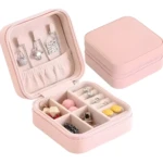 Mini organizador viajero de joyas rosa con collares, anillos y accesorios.
