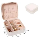 Mini organizador viajero para joyas abierto, con compartimentos y anillos dorados y plateados.