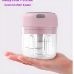 Mini picadora eléctrica recargable rosa sobre mano, ideal para ahorrar espacio en la cocina.