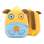 Mochila amarilla para niños con diseño de perro, orejas marrones, cara azul sonriente y compartimento con cremallera.