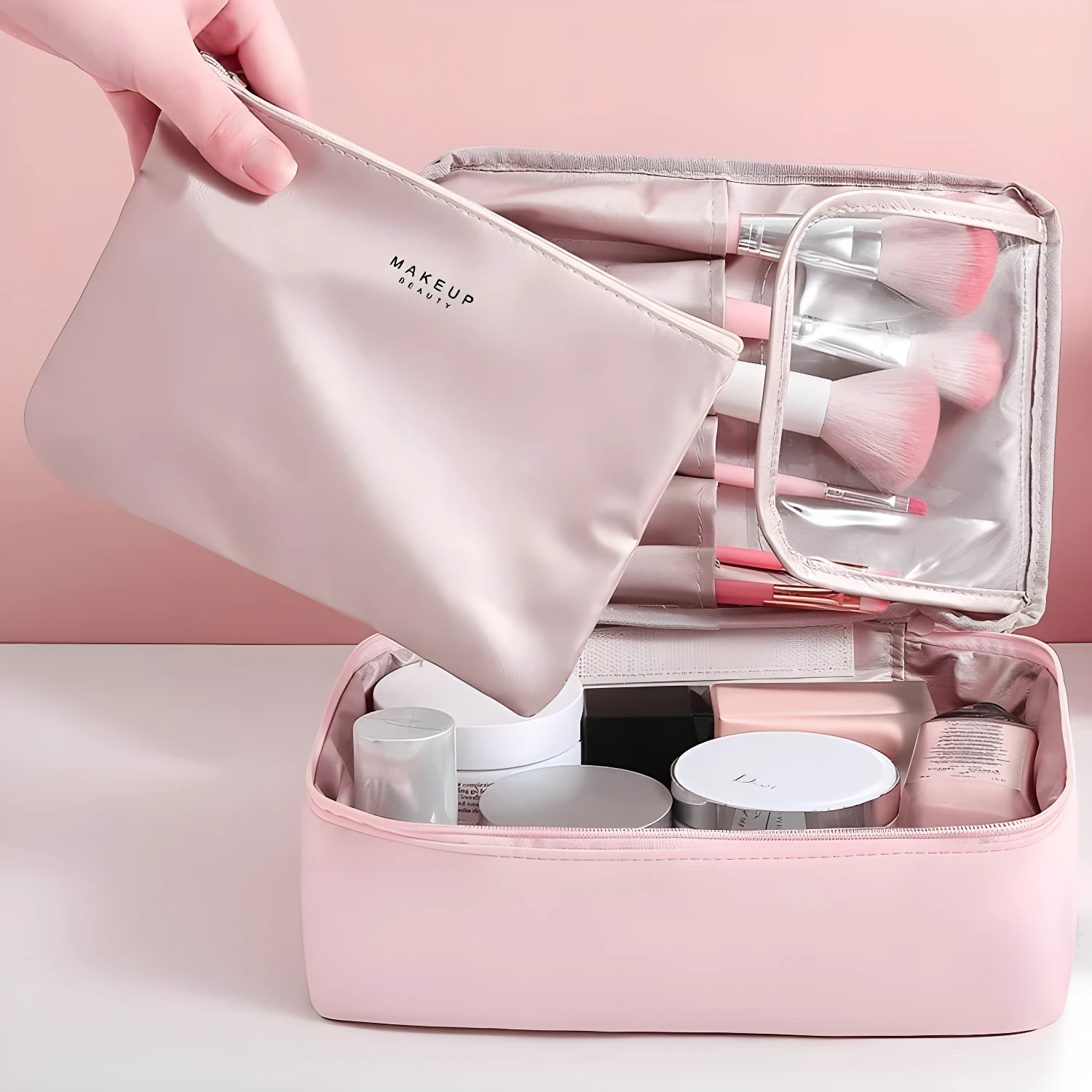 Neceser organizador de maquillaje de viaje, con brochas y productos de belleza en tonos rosas.