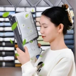 Organizador colgante de closet de 6 niveles con camisa dobrada para mujer en primer plano.
