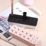 Organizador de maquillaje con compartimentos para labiales y brochas, color rosa y negro.