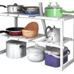 Organizador de cocina bajo lavaplatos blanco con ollas, sartenes, tetera y recipientes.
