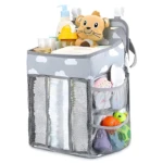Organizador de cuna gris con nubes, lioncito, pañales y juguetes.