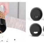 Mano sujetando molinillo de especias con semillas cayendo; tapas de organizador de especias.