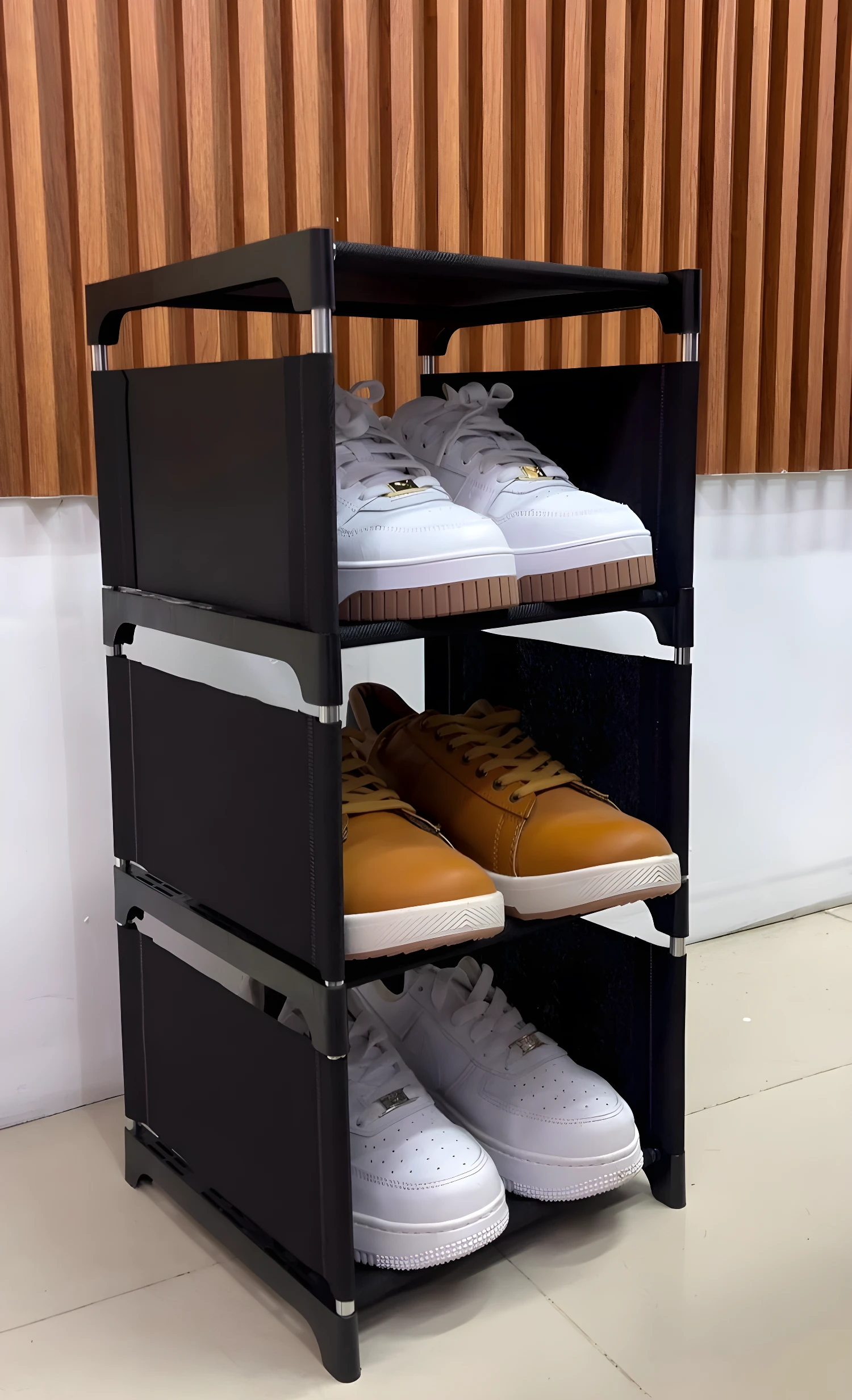 Organizador de zapatos 3 niveles en tela negra con tenis blancos y café.