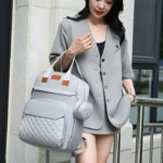 Pañalera gris con monedero, bolso moderno para viajar.