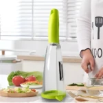Pelador y rallador de papas y verduras con diseño ergonómico en cocina con ensalada y pepinos.
