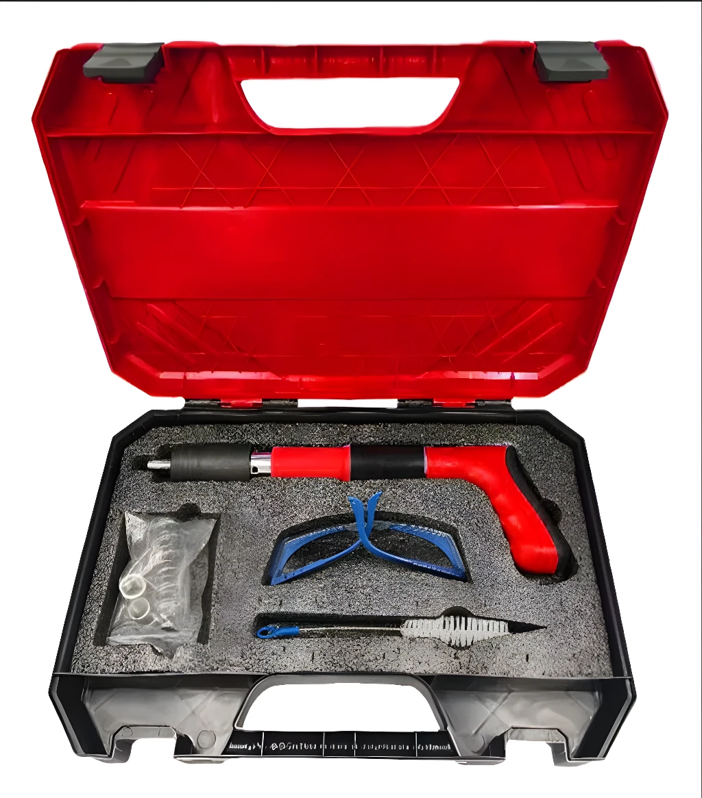 Pistola neumática para clavos de acero, con accesorios en su estuche rojo y negro.