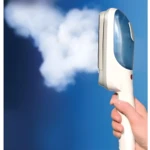 Plancha portátil Tobi expulsando vapor blanco sobre fondo azul cielo.