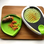 Rayador de ajo y jengibre Kitchener: rallando jengibre fresco en una tabla de madera.