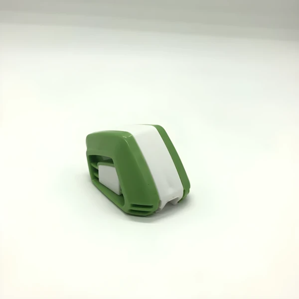 Reparador de plumilla verde y blanco en primer plano sobre fondo blanco.