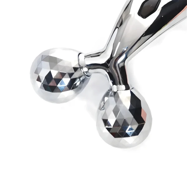 Rodillo facial y corporal 3D plateado con doble esfera facetada y mango brillante.