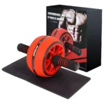 Rueda abdominal naranja con asas negras, tapete negro y caja de ejercicio fitness.