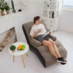 Sofá inflable reposa pies con mujer leyendo, mesa con frutas y planta decorativa.