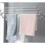 Tendedero de ropa plegable de aluminio con pantalones y toalla secándose.