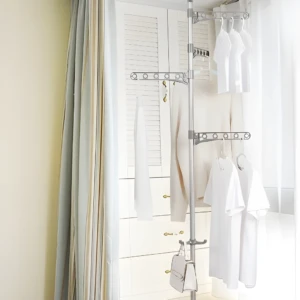 Tendedero vertical retráctil de piso para secar ropa blanca colgada en sus niveles.