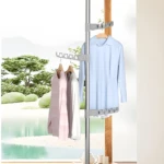 Tendedero vertical retráctil a techo con ganchos para ropa y vista a jardín.