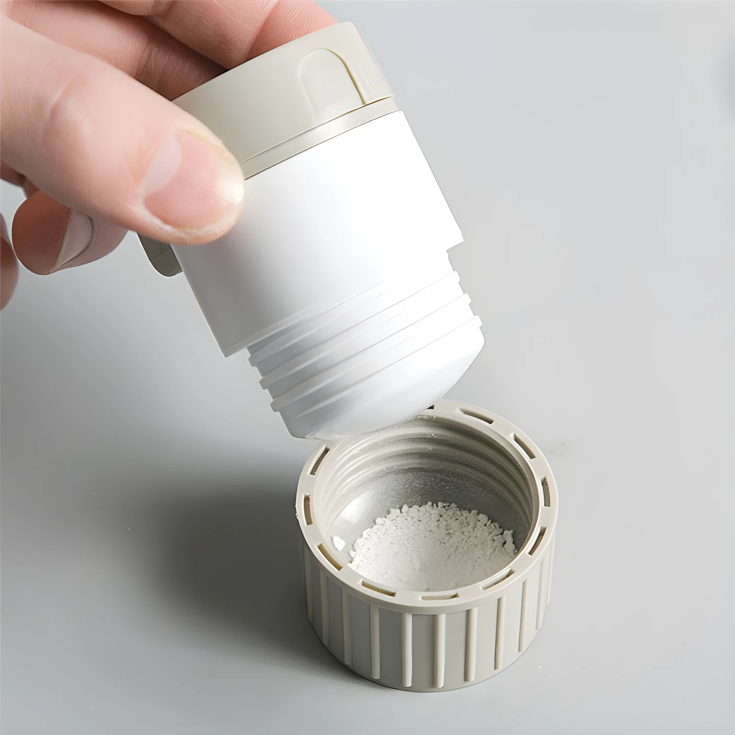 Triturador pulverizador de pastillas con tapa y compartimento para polvo blanco molido.