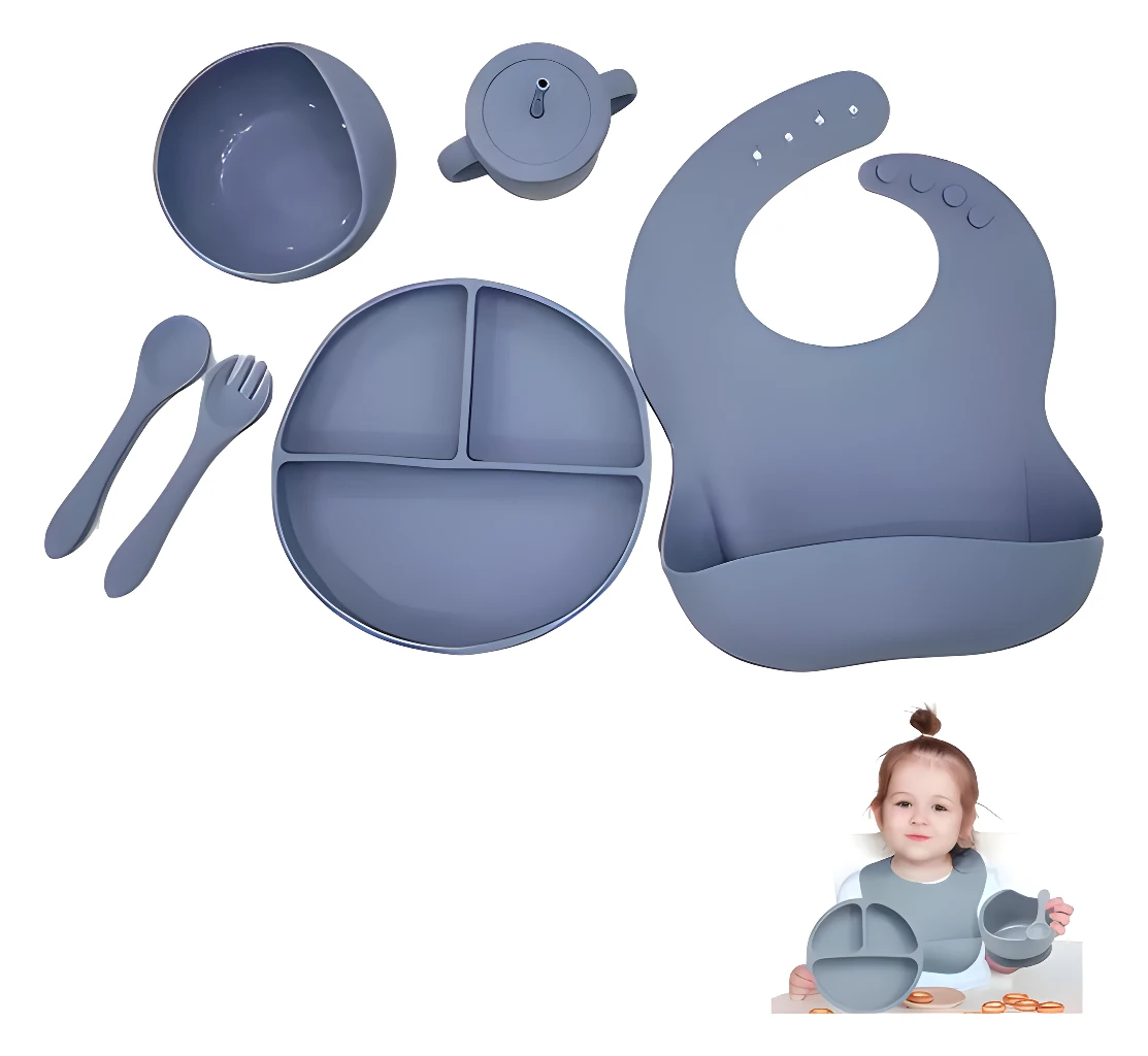 Vajilla de silicona para bebé con plato, tazón, cubiertos, babero y taza en tono gris.