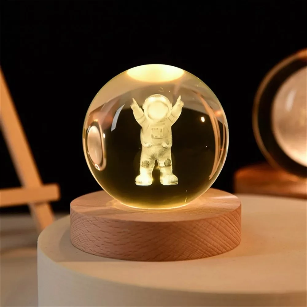 Lámpara 3D de astronauta en esfera de cristal con base de madera, ideal para escritorio nocturno.