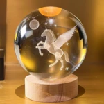 Lámpara de escritorio nocturna 3D con grabado de Pegaso en esfera de cristal sobre base de madera.